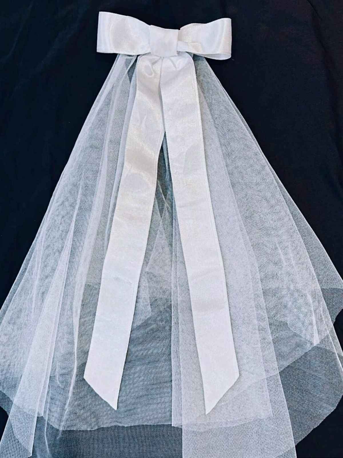 White tulle veil with a large bow on a dark background