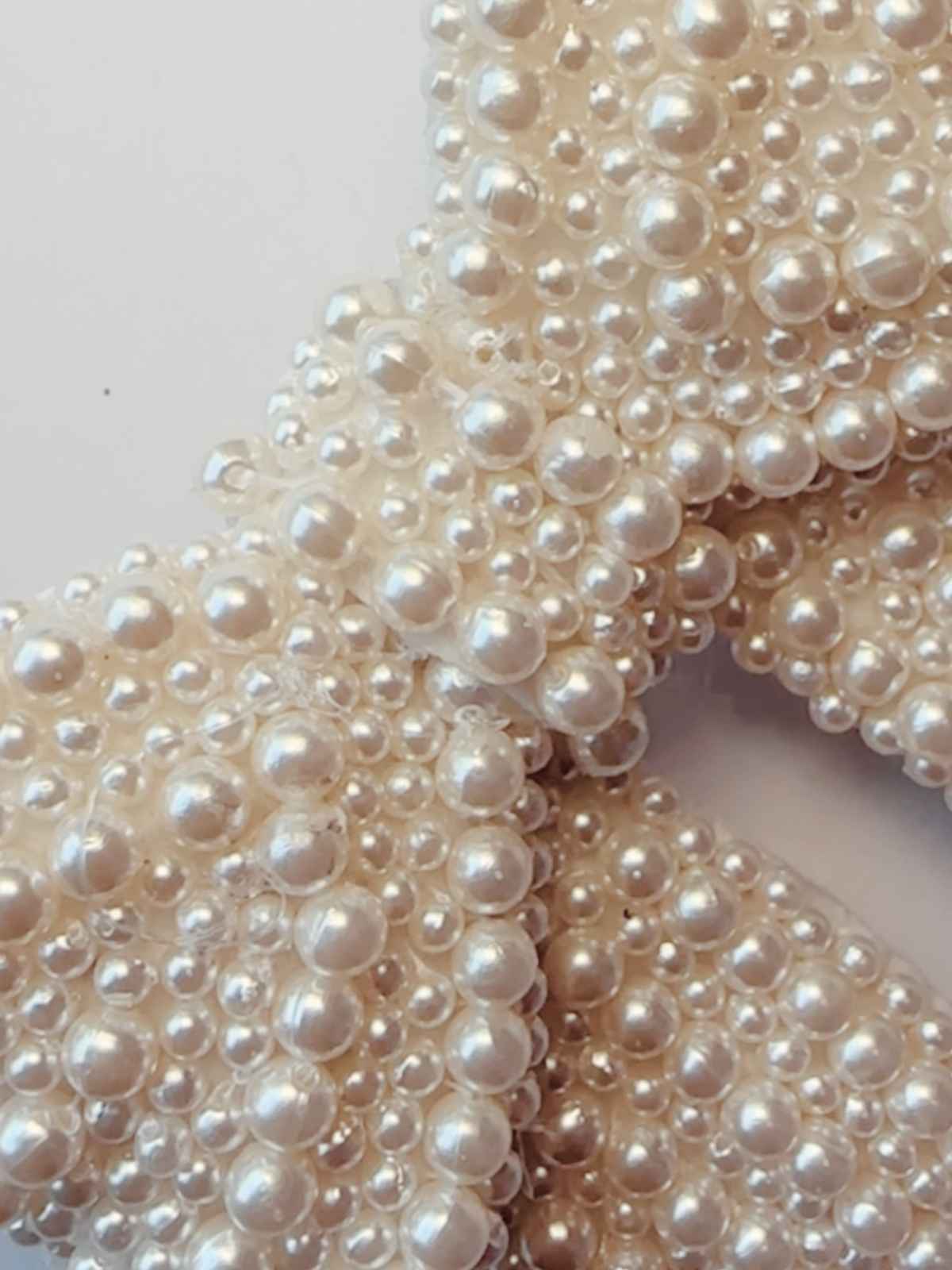 Close-up of white pearls of aria pearl bow