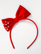 Red bow headband with heart cutouts on a white background