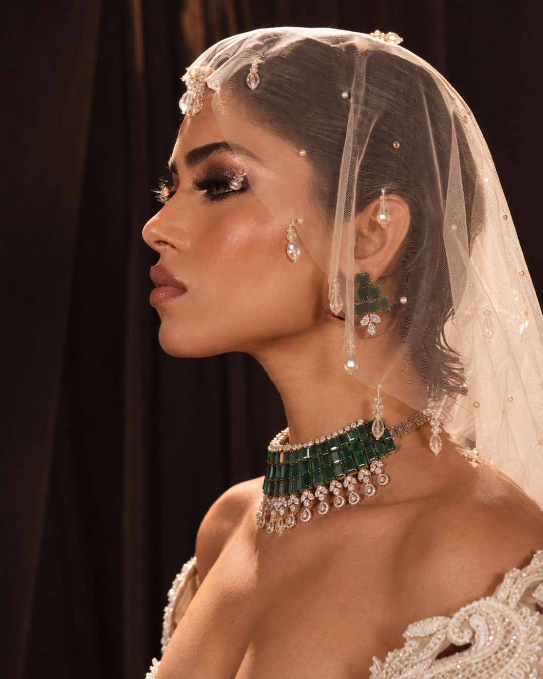 A model wearing white micro veil embellished by crystal stones and pearla
