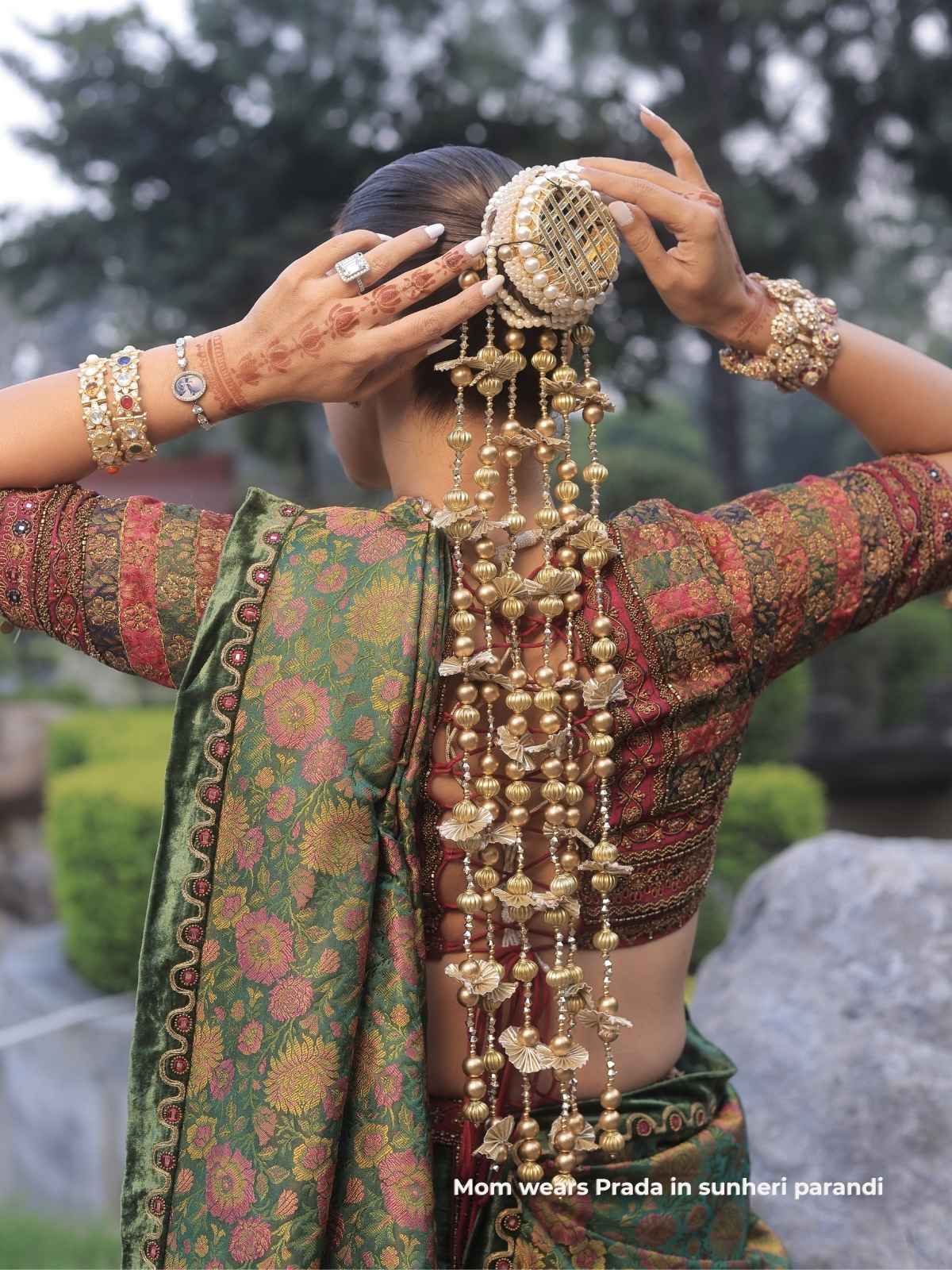 Woman adjusting sunheri parnadi outdoors with a blurred natural background