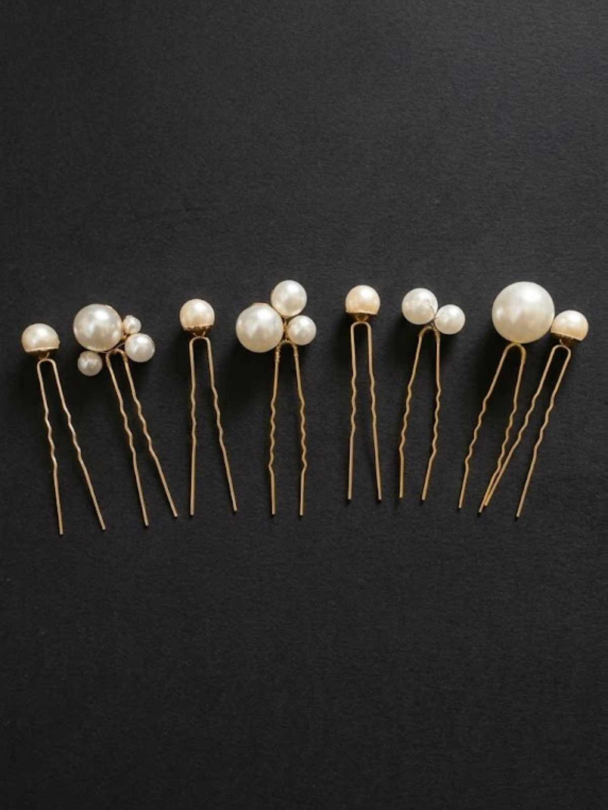 Set of 8 pearl gold bridal hairpins by loveknots on a black background