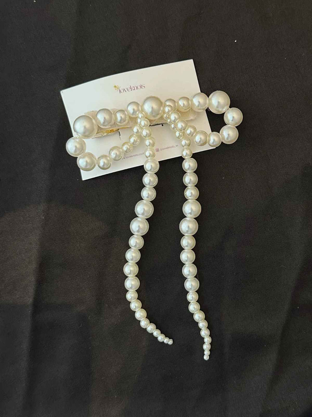 Pearl bow lying on black background