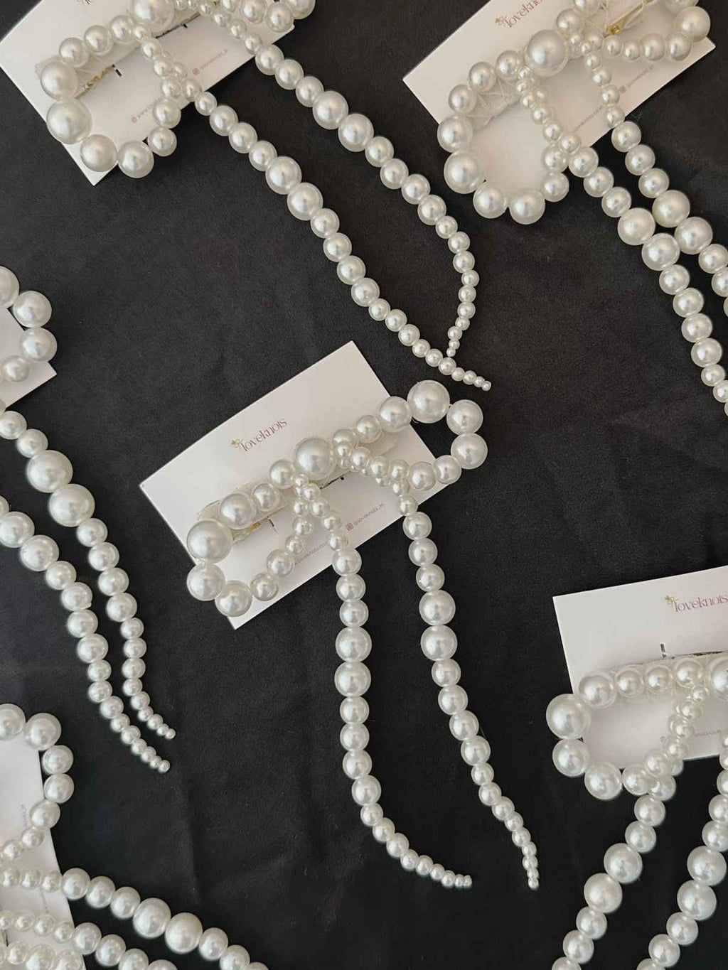 Many pearl bow lying on black background
