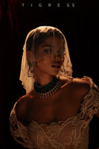 A women in shadow photo studio lighting wearing white gown and micro veil