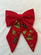 Red pashmina bow with green Christmas-themed decorations on a white background