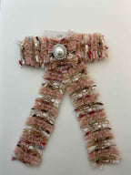 Tweed peach bow with pearl center on a white background