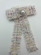 tweed bow and pearl center on a white background