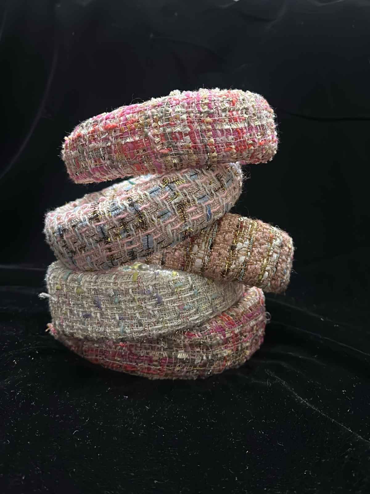 Stack of tweed padded hairband on a black background