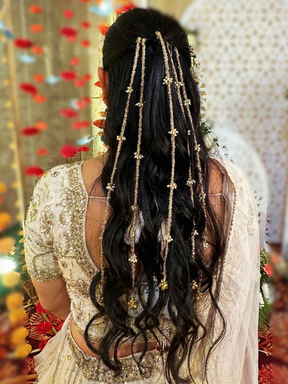 Woman with long curled hair with pearl ghungroo hair chain and parnadi tassels by loveknots