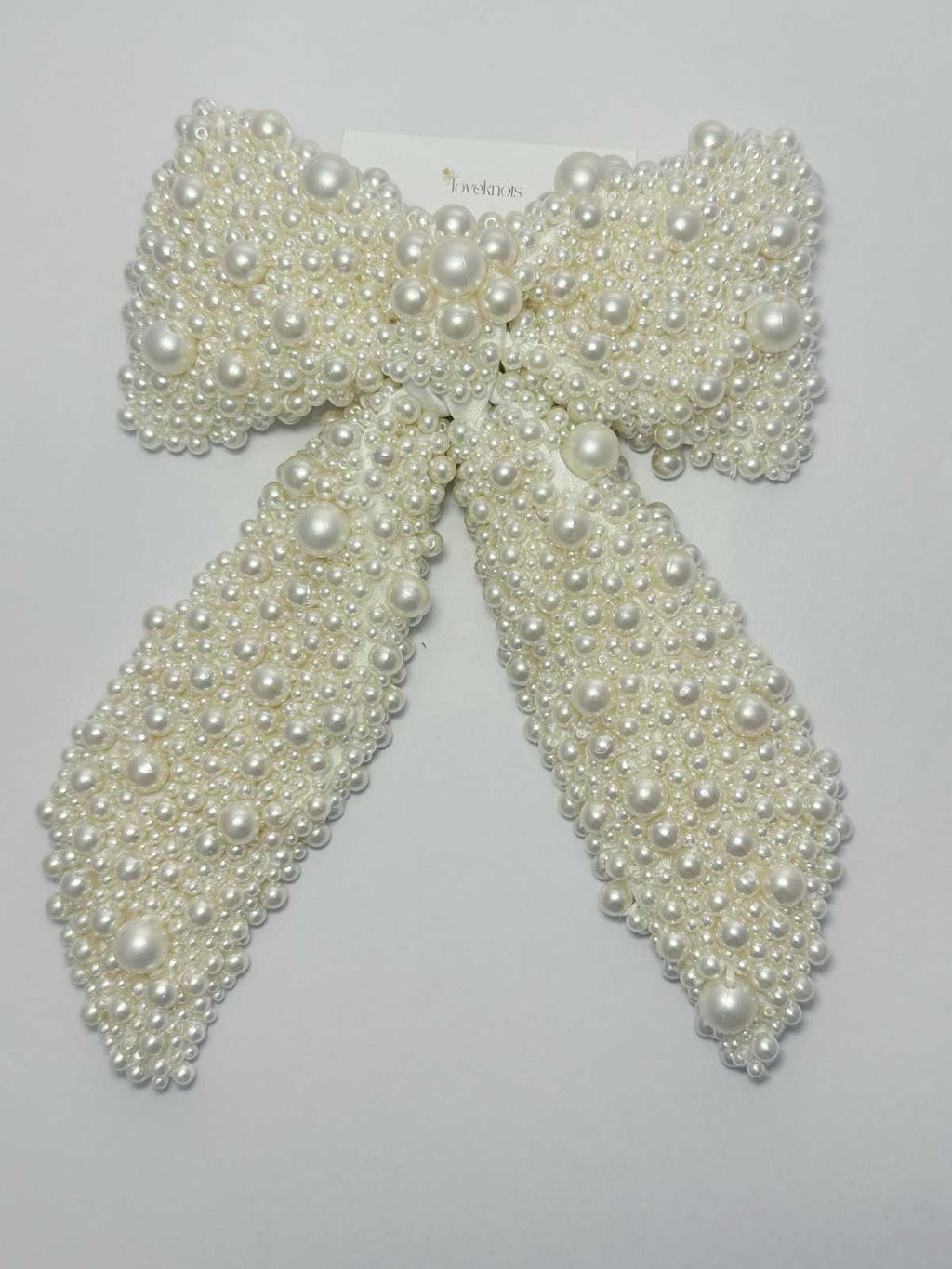 Pearl bow hair clip on a light white background