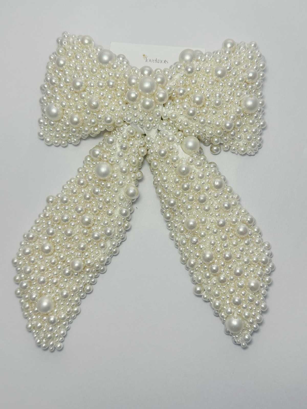 Pearl bow hair clip on a light white background