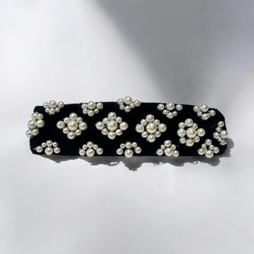 Black hair barrette with white pearl embellishments on a white background