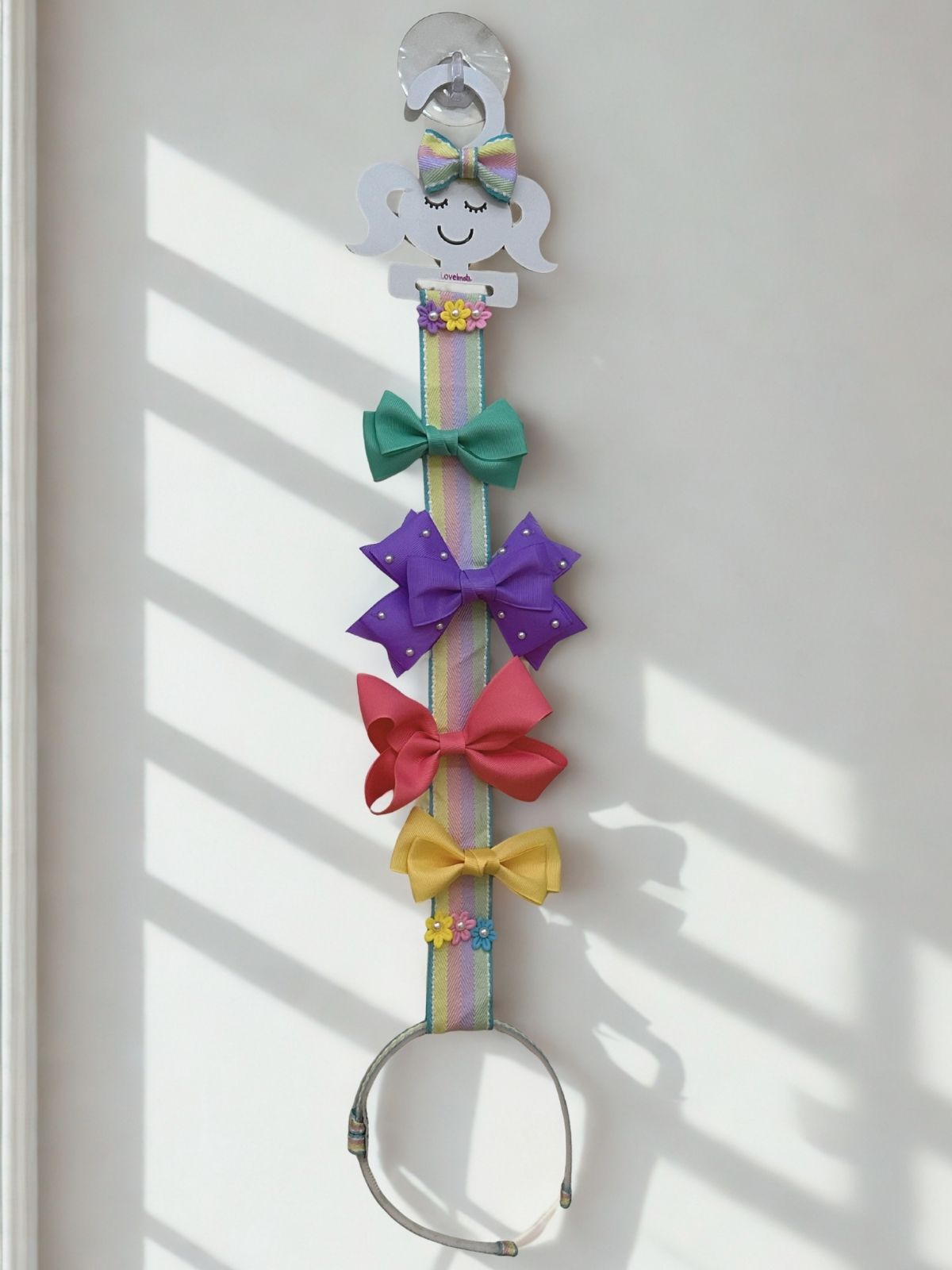 Hair bow holder with colorful bows and hairband on a white background
