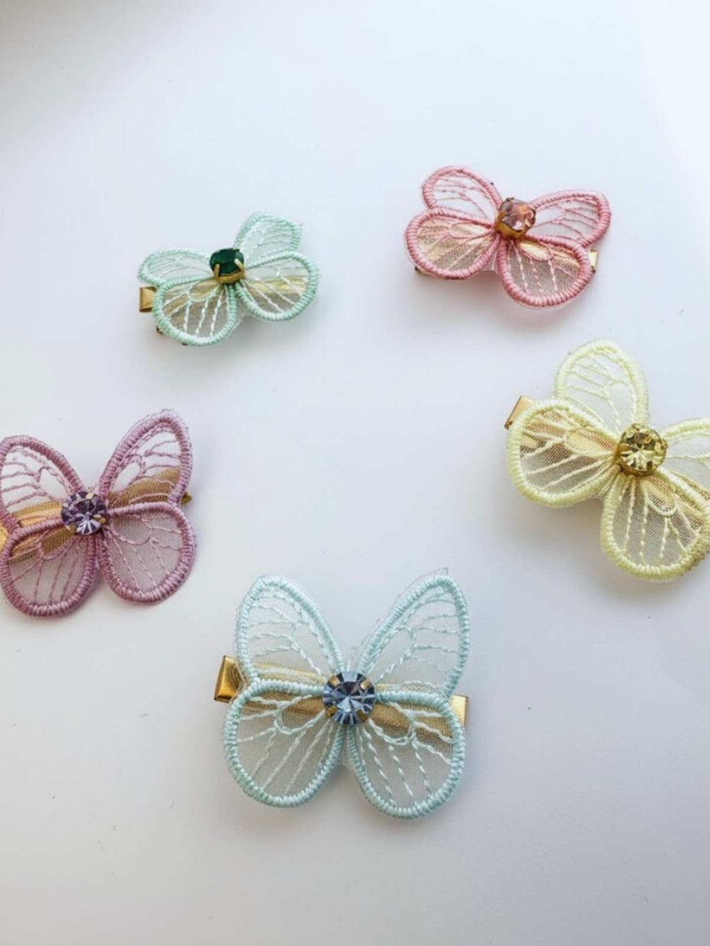 Five colorful butterfly-shaped hair clips on a light background