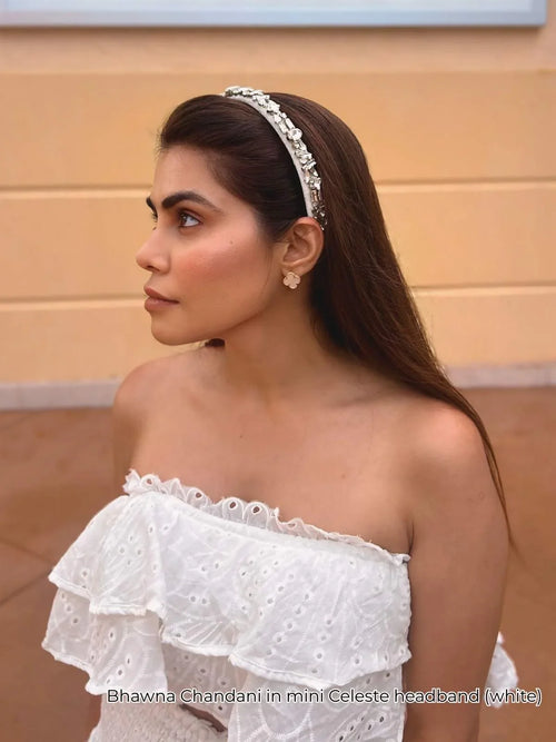 Woman wearing white embellished mini Celeste hairband, dressed in white off-shoulder top