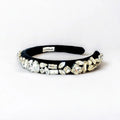 Black headband with crystal embellishments on a white background