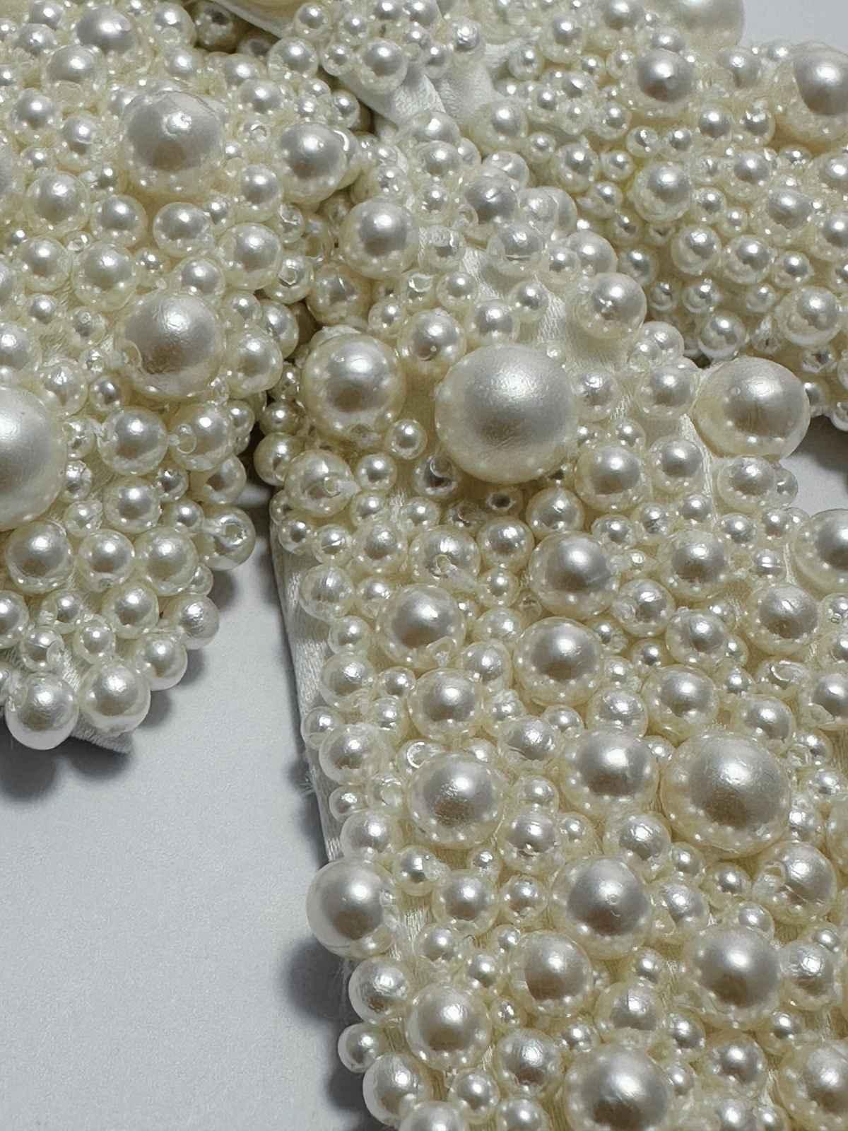 Close-up of a handmade pearl bow surface covered with white pearls 