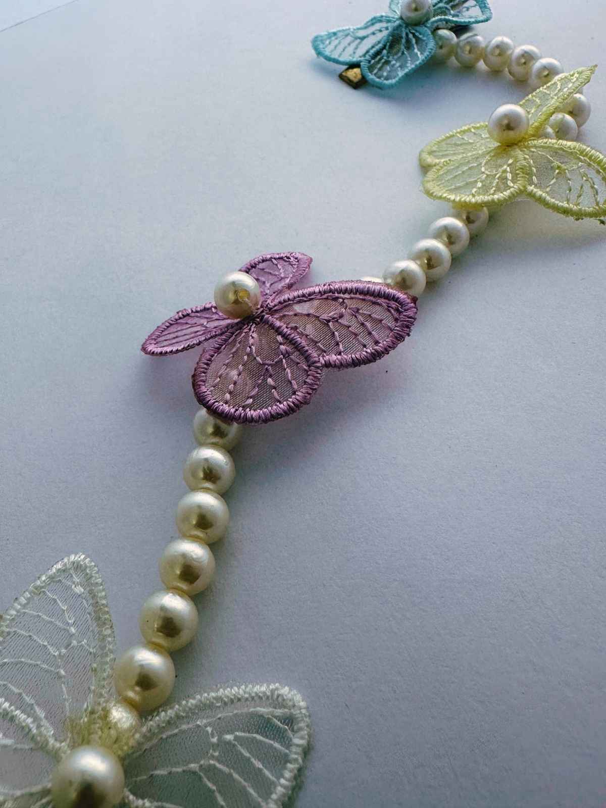hair accessories with butterfly-shaped beads on a light gray background