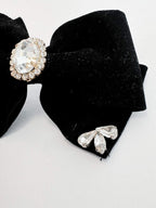 Black bow hair clip with crystal embellishments on a white background