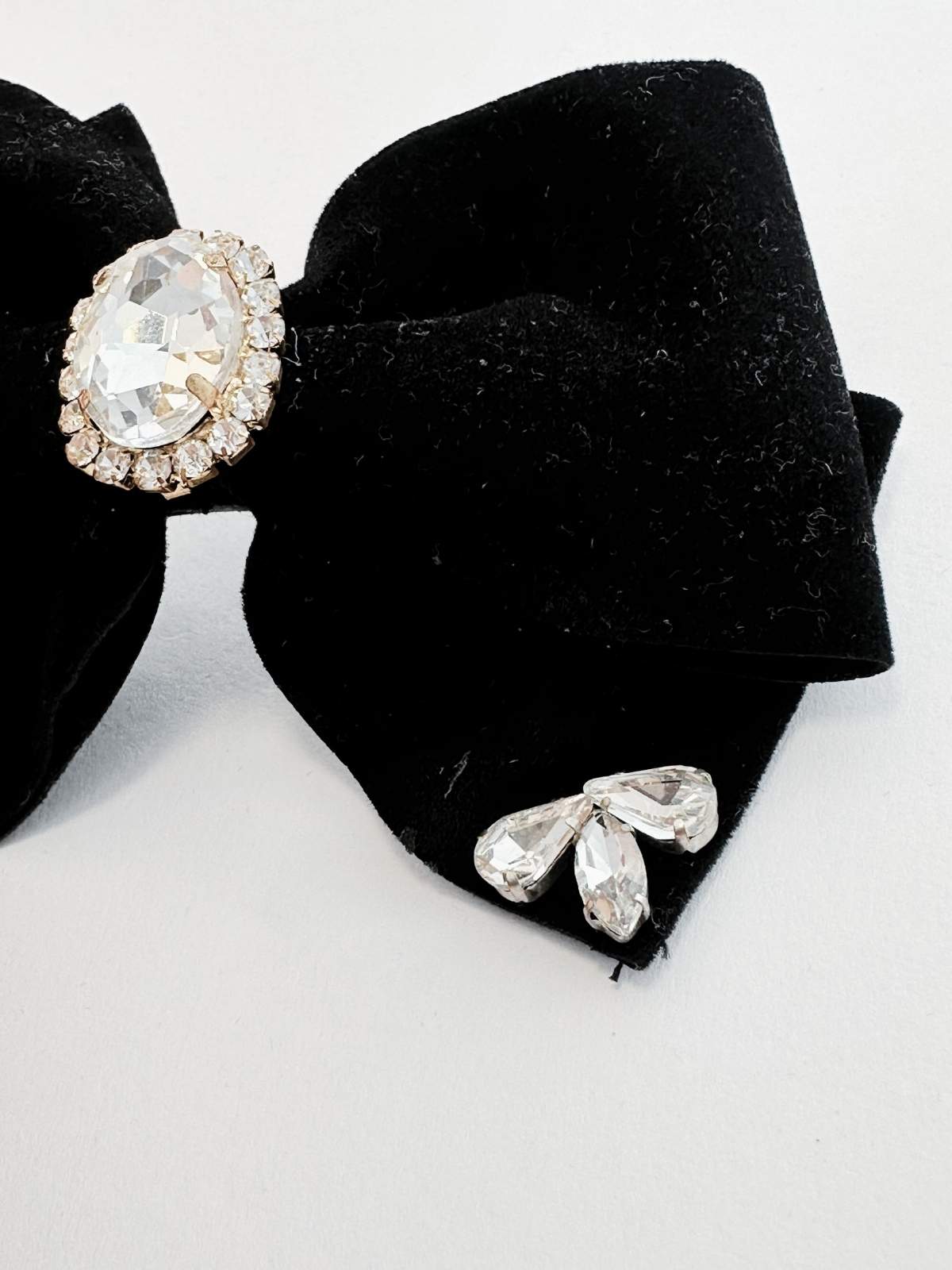 Black bow hair clip with crystal embellishments on a white background