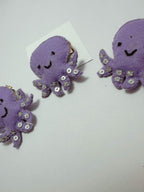 Purple octopus-shaped embellished hair clip on a white card with 'loveknots' branding.