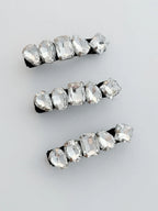 Set of three crystal hair clips on a light gray background