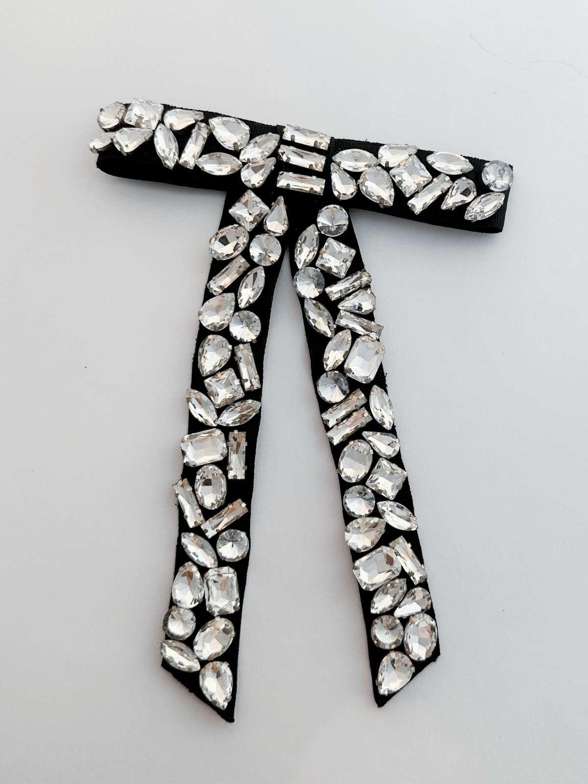 Black bow with silver rhinestones on a white background