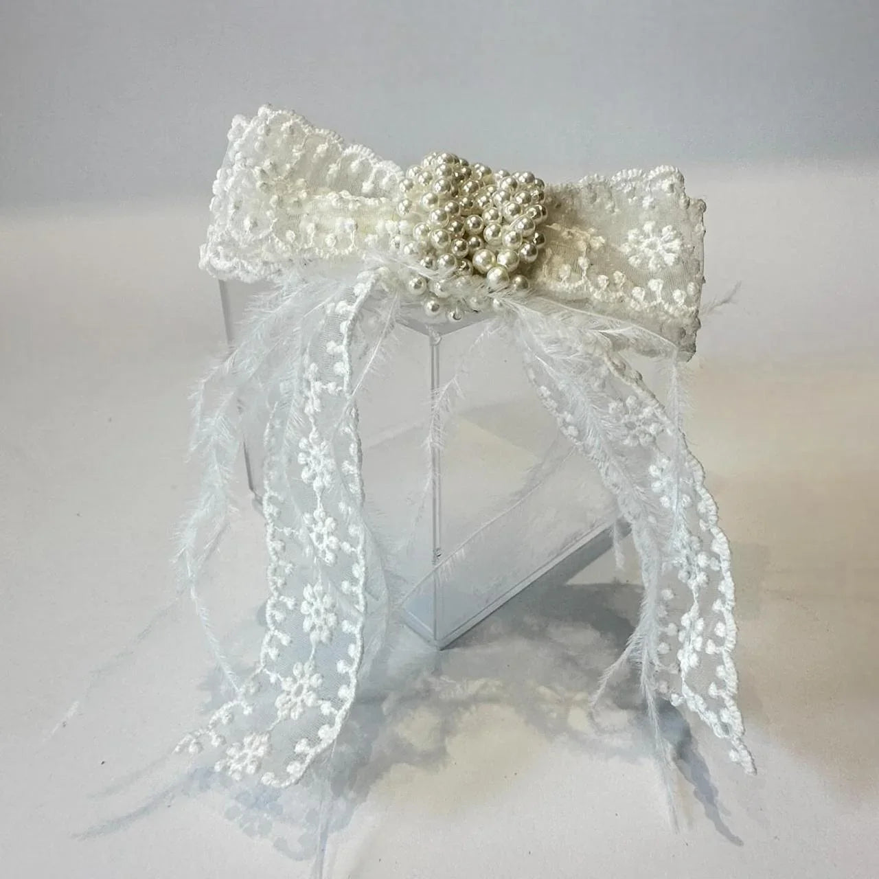 white lace bow with feathers and pearls in centre by loveknots
