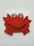 Red crab-shaped object with beads details on a white background