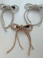 Three party wear crystal hair bows in three colors on a light background