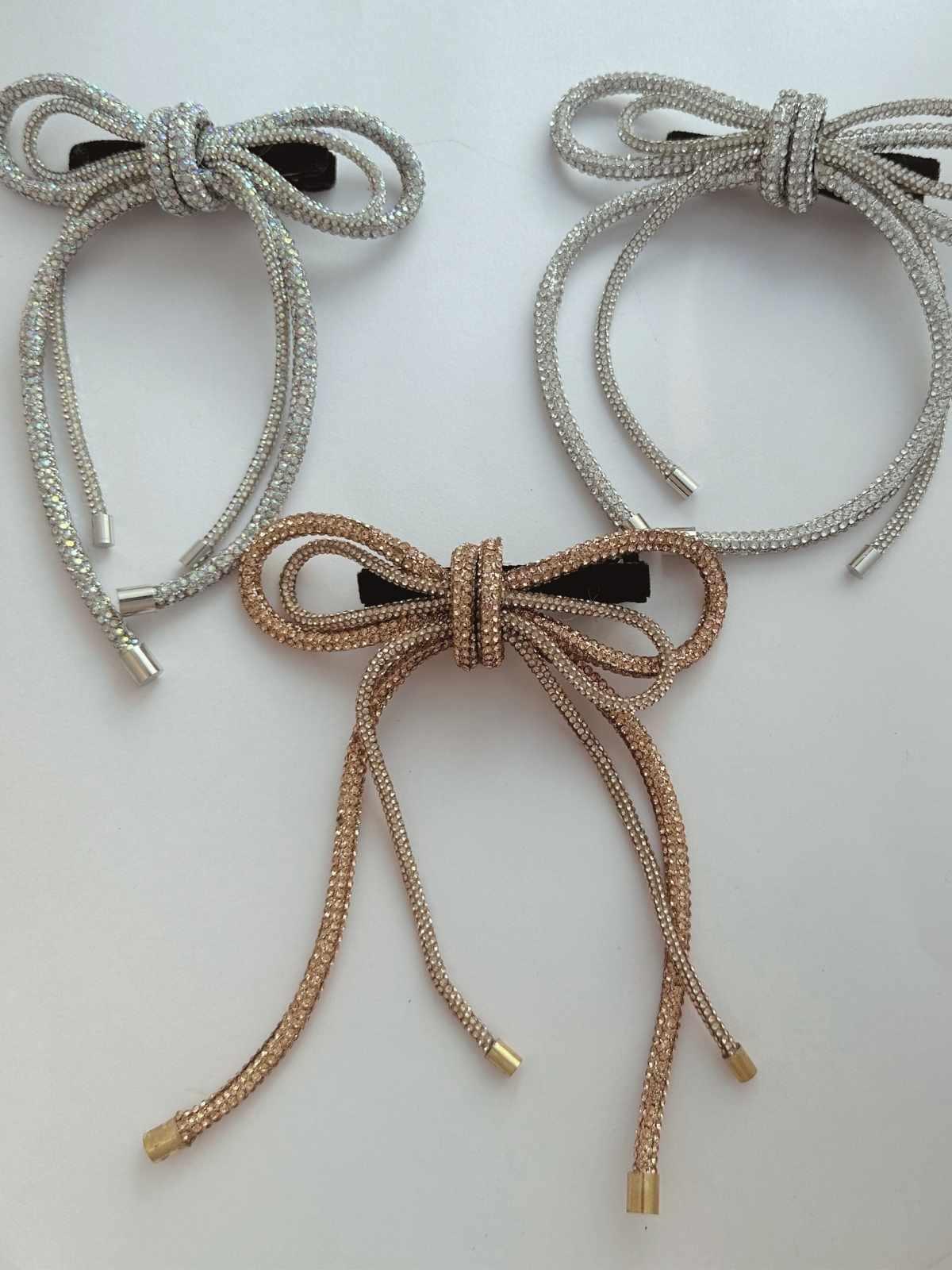 Three party wear crystal hair bows in three colors on a light background