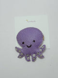 Purple octopus-shaped hair clip on a white card with 'loveknots' branding.