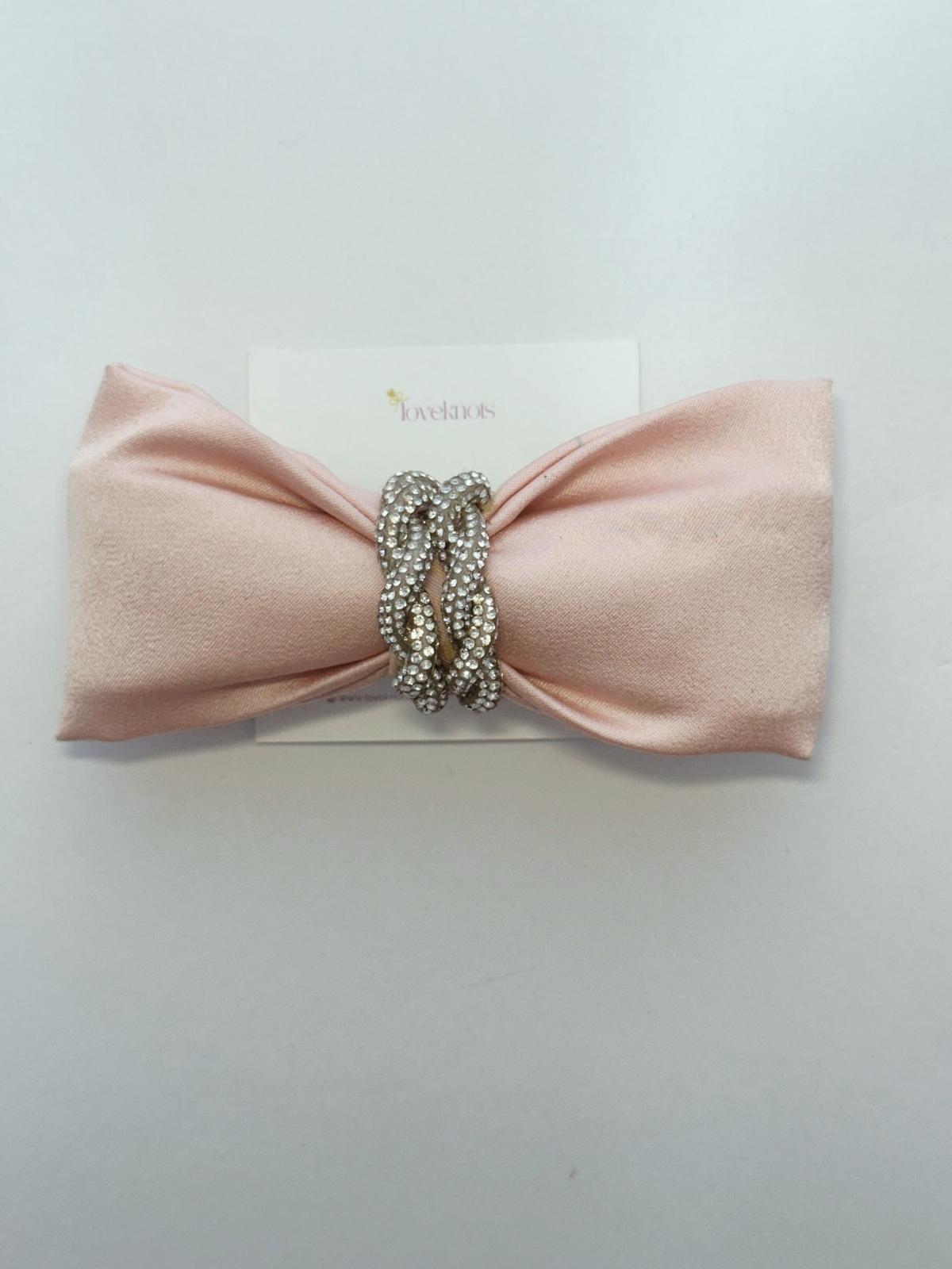 flatlay of blush pink bow with twisted crystal rope in centre handmade bow by loveknots