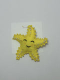 yellow star-shaped hair clip with pearl embellishments on a loveknots white background