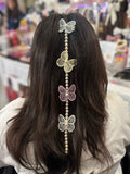 Person with decorative prandi hair accessories featuring butterflies and beads in a store setting