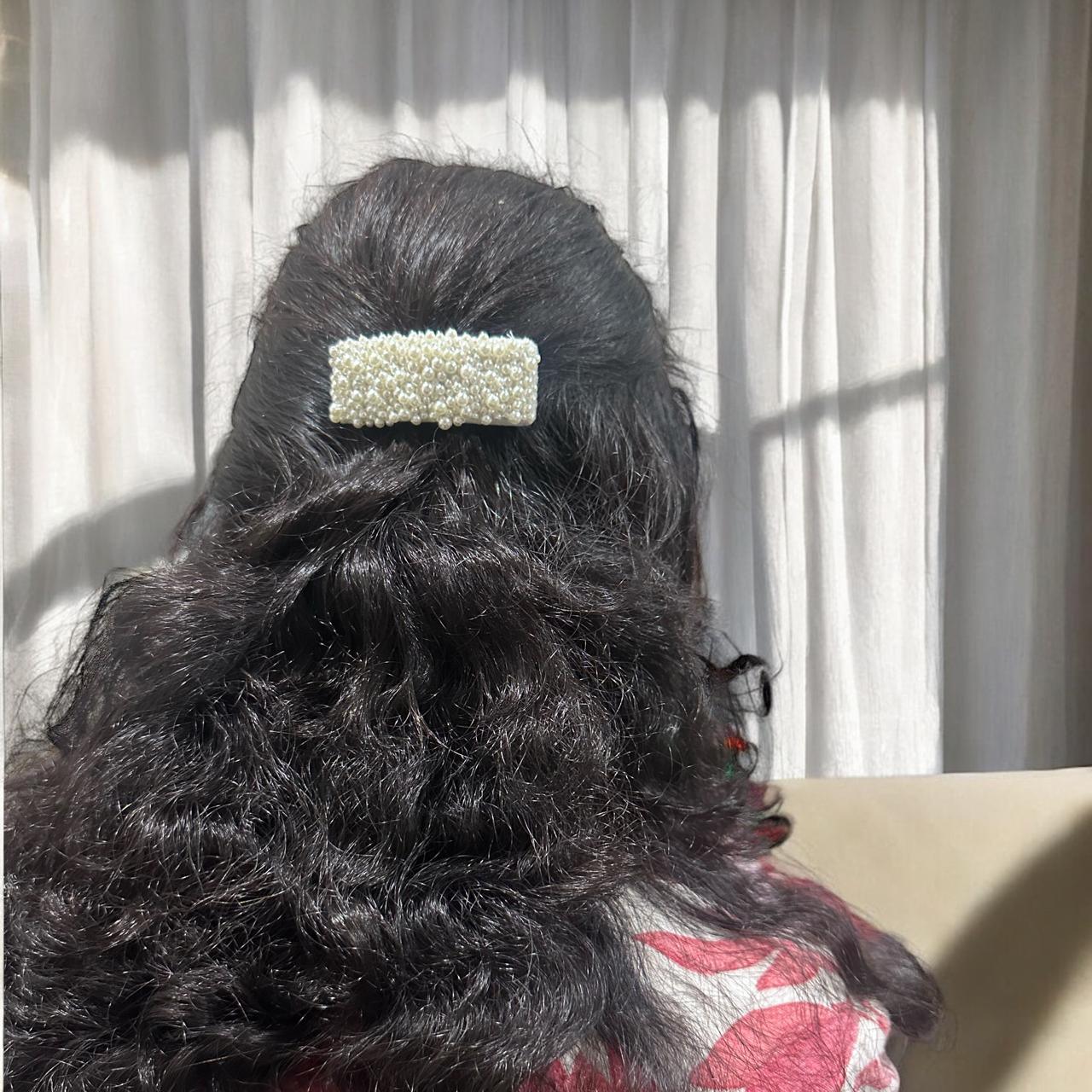 women wearing pearl hair clip in their hair against a light curtain background