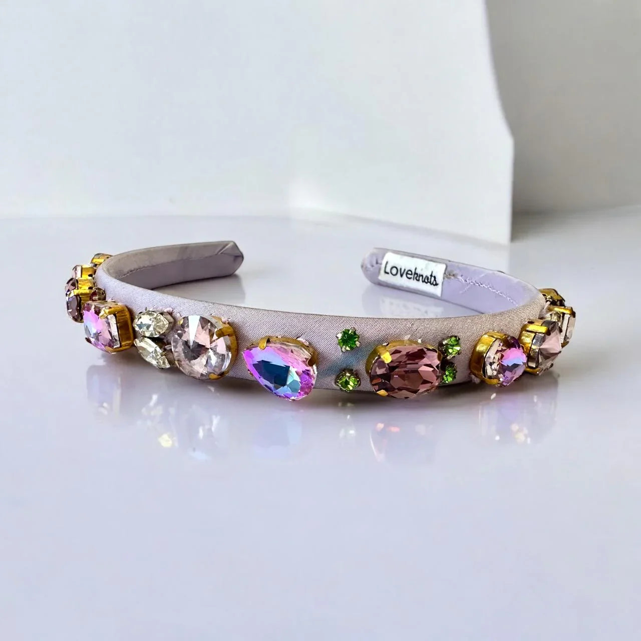 purple headband with colorful crystals on a white background