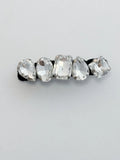 Hair clip with clear rhinestones on a light gray background