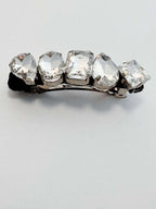 Hair clip with clear rhinestones on a light gray background