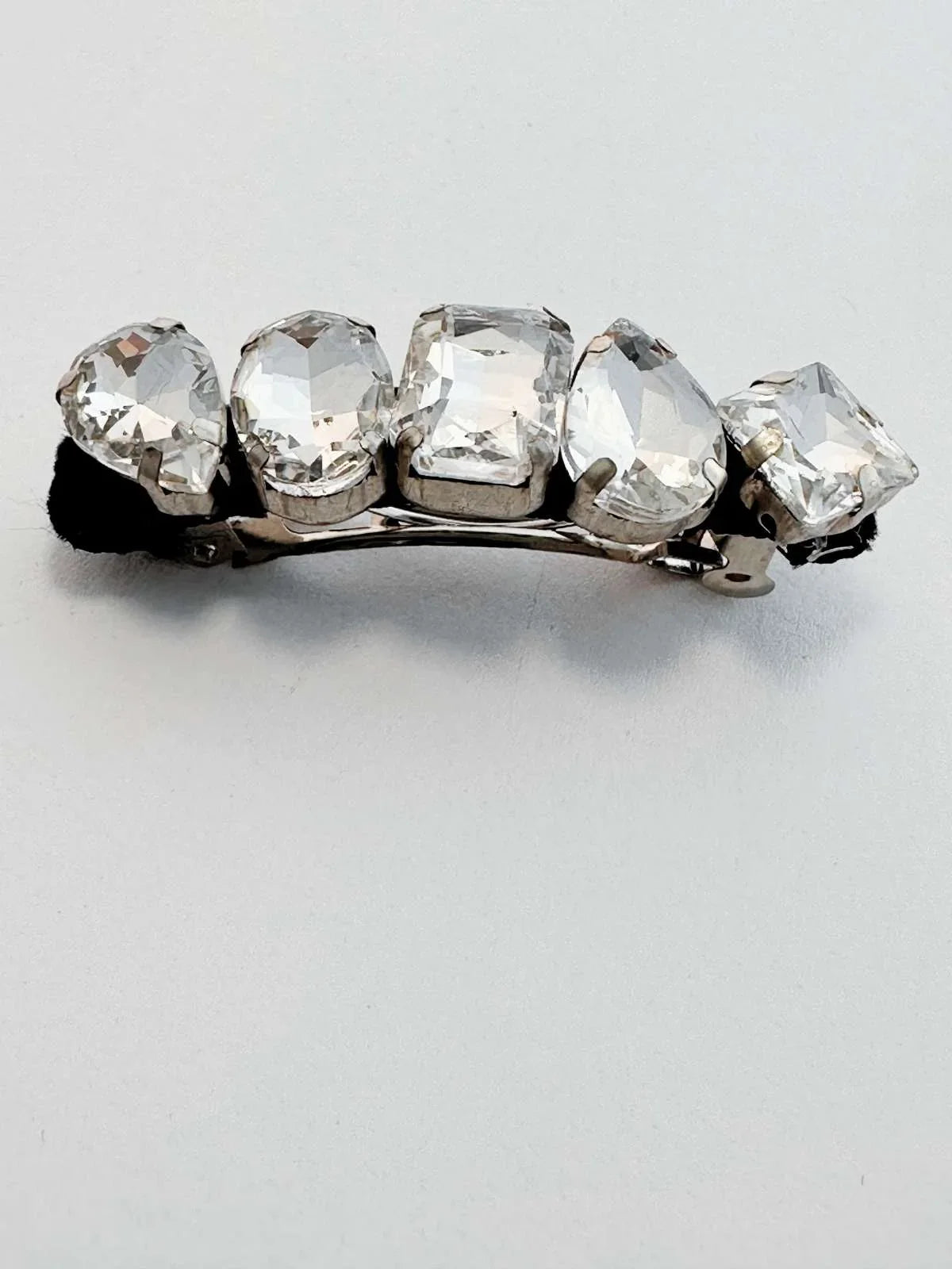 Hair clip with clear rhinestones on a light gray background