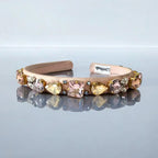 pink headband with gemstones on a reflective surface