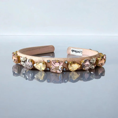 pink headband with gemstones on a reflective surface