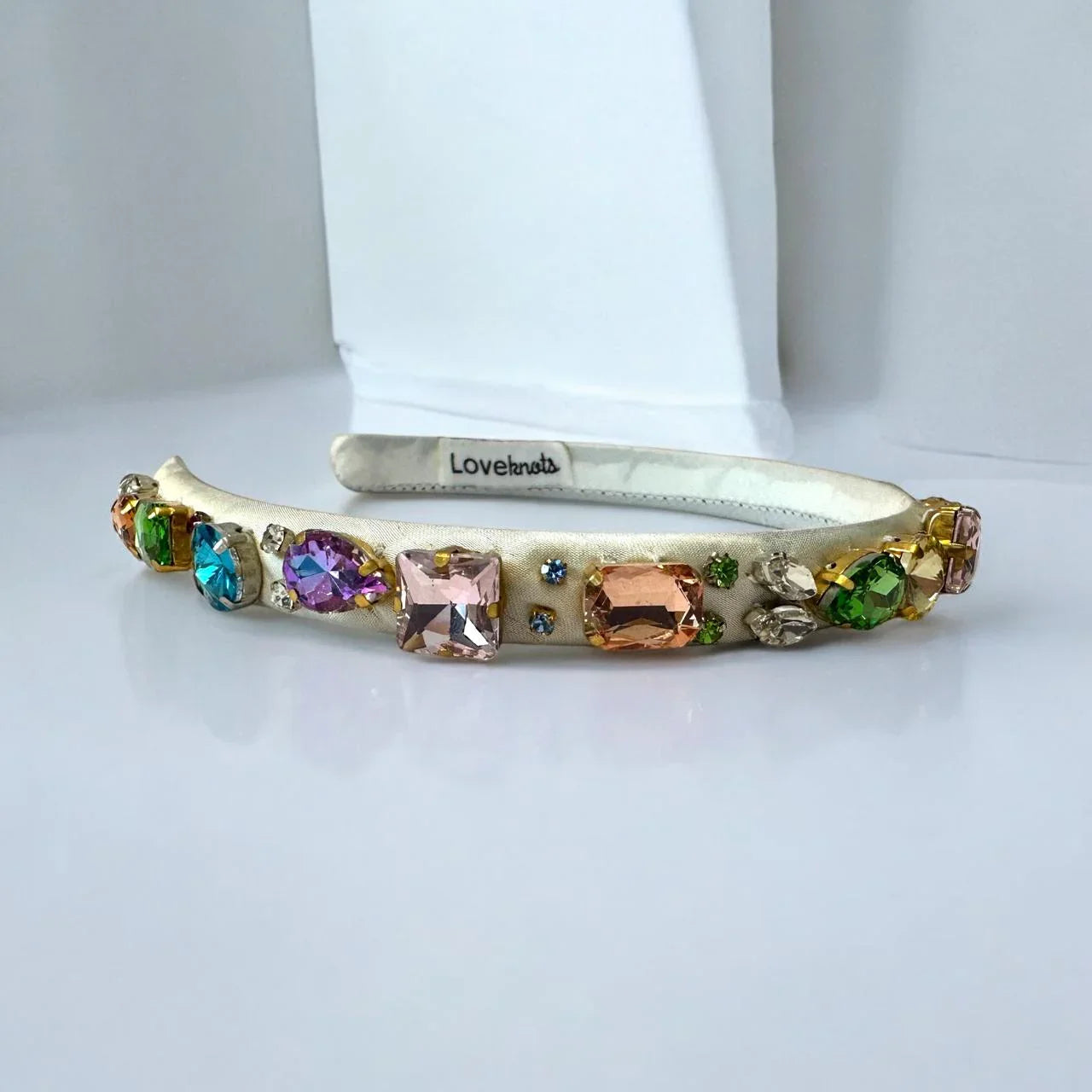 white hairband with colorful gemstones on a white background