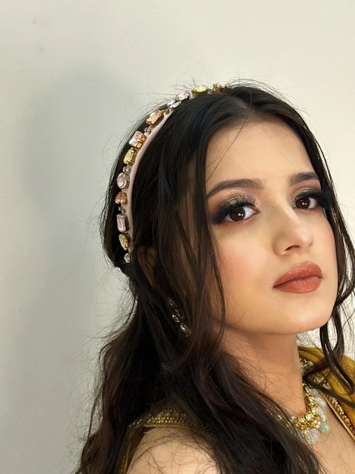 model Leah arora wearing a decorative pink aura headband by loveknots with a plain background